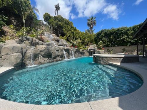 a pool with a waterfall and a swimming pool at Destination #50 in Placentia