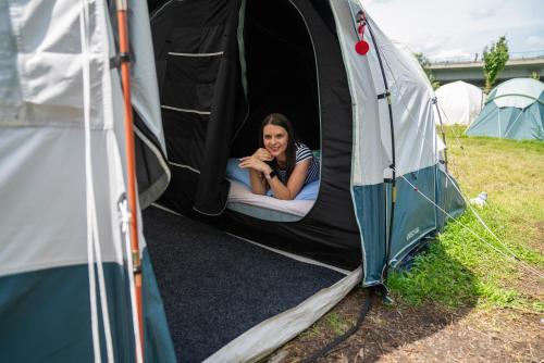 a woman laying on a mattress in a tent at Kemp Děčín in Děčín