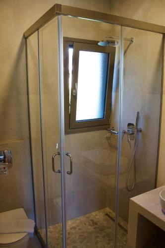 a shower with a glass door in a bathroom at Notos Luxury Studios in Katelios