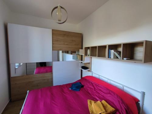a bedroom with a bed with a pink blanket at Maison Lydie in Velletri