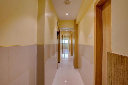 a hallway with white walls and a long corridor at FabHotel Starwood Residency - Behind BMW Car Showroom in Navi Mumbai