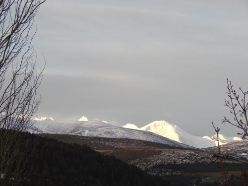 una montaña cubierta de nieve en la distancia con montañas en el fondo en Casas Rurales Cimera yBrincalobitos, en Hoyos del Espino