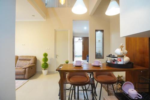 a living room with a wooden table and chairs at Griya Seturan Homestay Jogja in Seturan