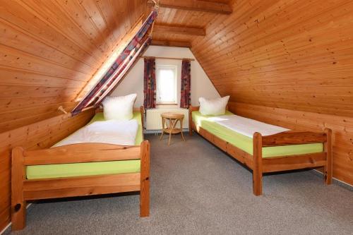 a bedroom with two beds in a log cabin at Haus Kajedeich FeWo Robbe in Bensersiel