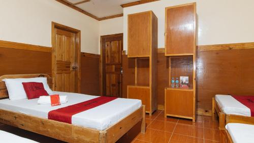 a bedroom with two beds and wooden cabinets at RedDoorz @ Sagada Sunrise View Homestay in Sagada