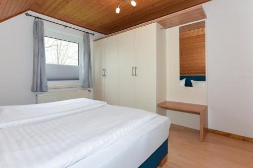 Ένα ή περισσότερα κρεβάτια σε δωμάτιο στο Haus Hafeneck FeWo Deichblick
