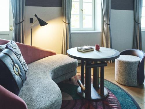 a living room with a couch and a table at Hotel Indigo Nagasaki Glover Street by IHG in Nagasaki