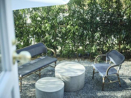 two chairs and a table with two chairs and a tree at Hotel Indigo Nagasaki Glover Street by IHG in Nagasaki