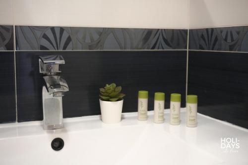 a bathroom sink with a faucet and several bottles ofodorizers at Holidays 15K Empuriabrava in Empuriabrava