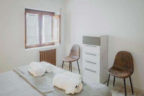 a bedroom with two chairs and a bed with towels at Casa Tilde in Matapozuelos