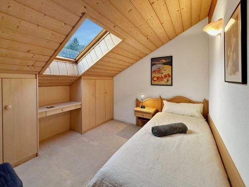 a bedroom with a bed in a room with a window at Family Penthouse with view of the Swiss Alps in Mollens