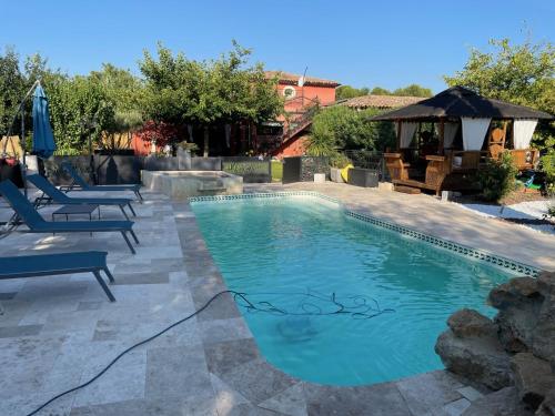 une piscine avec deux chaises et un parasol dans l'établissement Maison Provence plain pied avec Air de jeu enfants, à Aix-en-Provence