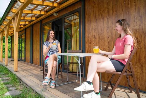 two women sitting at a table on the porch of a house at Kemp Děčín in Děčín
