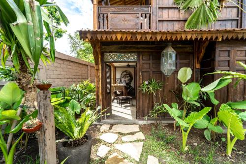 a house with a dog sitting in the doorway at Salty Siesta Stays in Selong Belanak