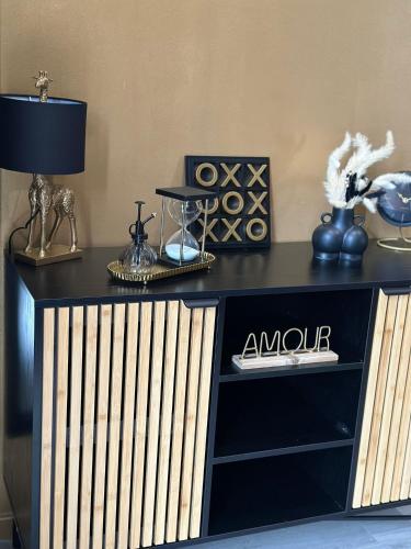 a black dresser with a lamp on top of it at Villa QUEEN Marseille avec jardin, piscine et spa chauffé interieur - 15 couchages in Marseille