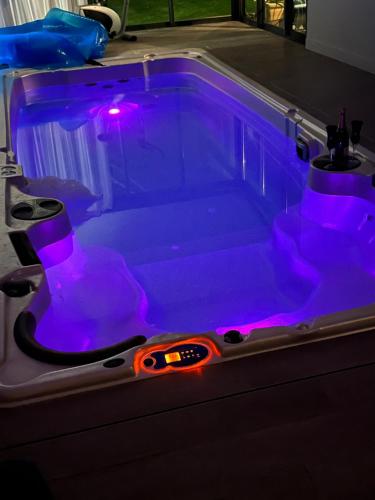 a bath tub with purple lights in it at Villa QUEEN Marseille avec jardin, piscine et spa chauffé interieur - 15 couchages in Marseille