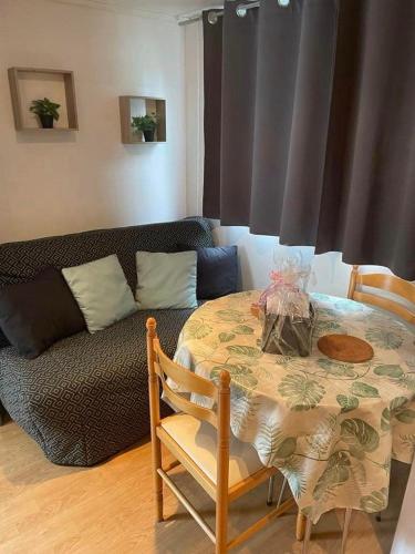 un salon avec une table et un canapé dans l'établissement L'aubélie, à Agde