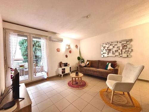 un salon avec un canapé et une télévision dans l'établissement Le 14 - Spacieux Deux Chambres, à Nîmes