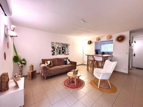 un salon avec un canapé et une table dans l'établissement Le 14 - Spacieux Deux Chambres, à Nîmes