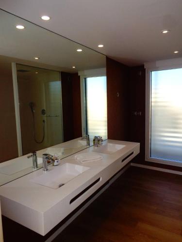 une salle de bain avec deux lavabos et un grand miroir dans l'établissement NAUTILIA 105 - DUPLEX LUXE EXCELLENCE 2 personnes, au Cap d'Agde