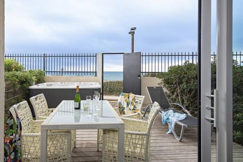- une table et des chaises sur une terrasse donnant sur l'océan dans l'établissement NAUTILIA 106 - Supérieure Luxe avec Jacuzzi 2 personnes, au Cap d'Agde