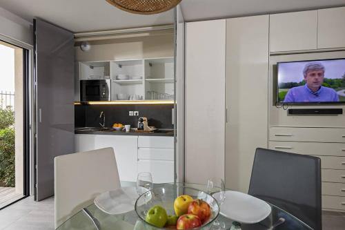 - une cuisine avec une table en verre et un bol de fruits dans l'établissement NAUTILIA 106 - Supérieure Luxe avec Jacuzzi 2 personnes, au Cap d'Agde