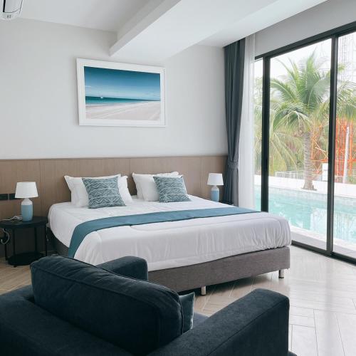 a bedroom with a large bed and a couch at Sand Dance Hotel in Prachuap Khiri Khan