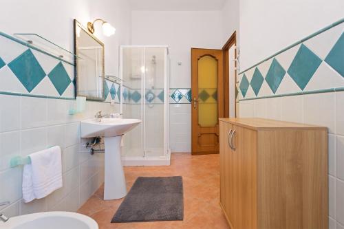 a bathroom with a sink and a toilet and a mirror at Domu Elgive in Tertenìa