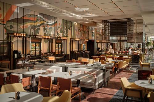 ein Restaurant mit Tischen und Stühlen und eine Bar in der Unterkunft Hyatt Centric Gaoxin Xi'An in Xi'an