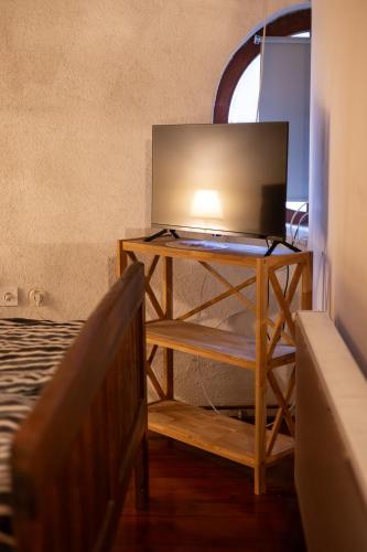a television on a stand in a room with a bed at Ruralna kuća za odmor Gerstmajer in Zmajevac