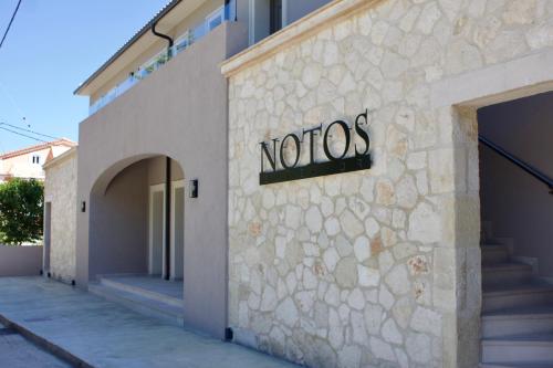 a notos sign on the side of a building at Notos Luxury Studios in Katelios