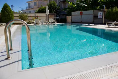 a large swimming pool with blue water at Notos Luxury Studios in Katelios