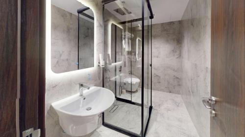 a bathroom with a sink and a glass shower at How inn Hotel in Al Madinah