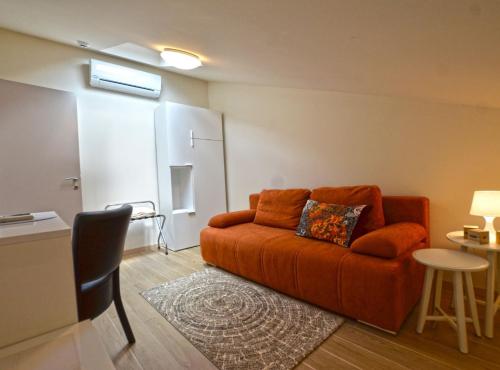 a living room with an orange couch and a table at Tranquil Getaway with Shared Pool in Bale in Bale