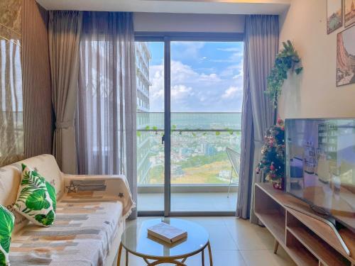 a living room with a couch and a large window at The Sóng Vũng Tàu - Thương's Homestay in Vung Tau