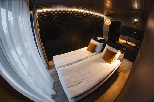 a bedroom with a large bed with yellow pillows at Hotel Ylläsrinne Deluxe in Ylläsjärvi
