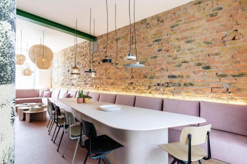 a dining room with a white table and pink chairs at Villa Plage Ensorpark in Ostend