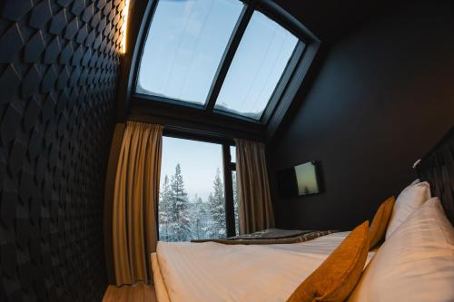 a bedroom with a large window and a bed at Hotel Ylläsrinne Deluxe in Ylläsjärvi