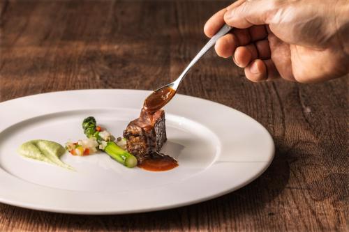 a person eating a plate of food with a fork at Four Points by Sheraton Seoul, Guro in Seoul