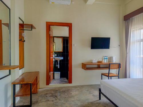a bedroom with a bed and a mirror and a sink at BRICK HOUSE - Unique & Central in Selaparang