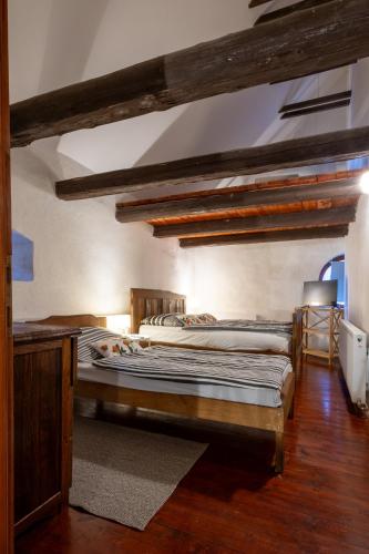 two twin beds in a room with wooden floors at Ruralna kuća za odmor Gerstmajer in Zmajevac