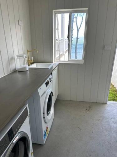 a laundry room with a sink and a washing machine at Dreamy Lake Retreat & Sunsets in Lake Heights