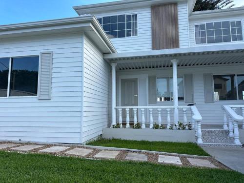 a white house with a porch and a lawn at Dreamy Lake Retreat & Sunsets in Lake Heights