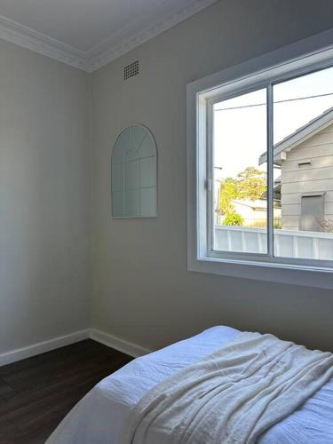a white bedroom with a bed and a window at Dreamy Lake Retreat & Sunsets in Lake Heights