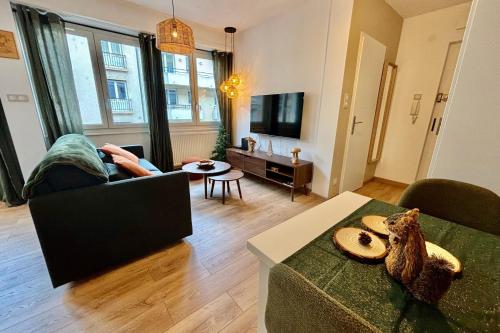 une personne assise sur un canapé dans un salon dans l'établissement Nature & Breeze - Heart of Strasbourg, à Strasbourg