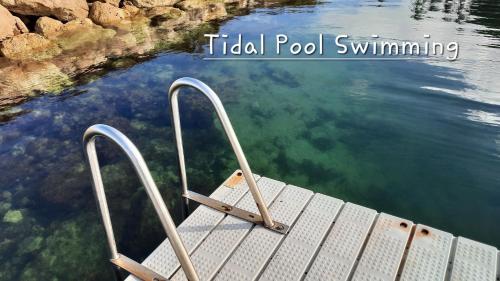 a wooden dock in a body of water at Tidal Pool Spa-Retreat - Central Kingscote in Kingscote