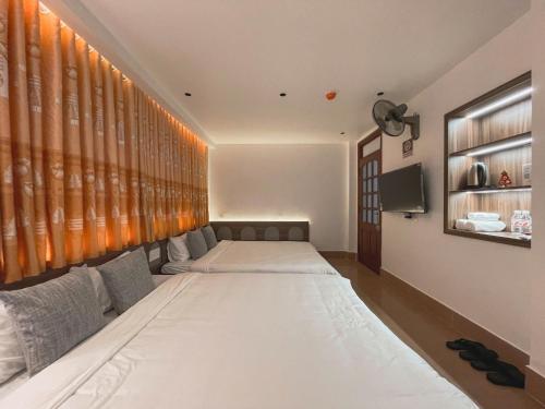 a room with two beds and a tv in it at Chi's House Cao Bang in Hoàng Ngà