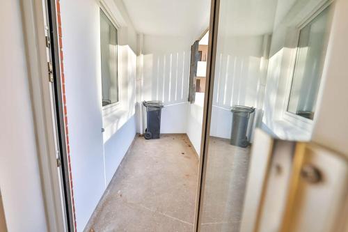 a hallway with two windows and two trash cans at Meersinn Ferienwohnung Brake in Harrierwurp