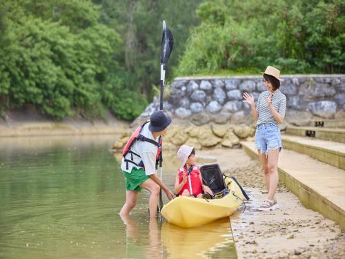 a group of children playing in a boat in the water at Yambaru Experience Hotel Nunganiku in Higashi