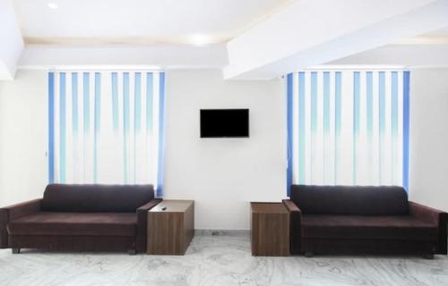 two couches sitting in a room with windows at The Hotel Lotus Prime in Jaipur